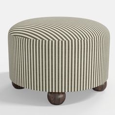 a striped ottoman sitting on top of a wooden base