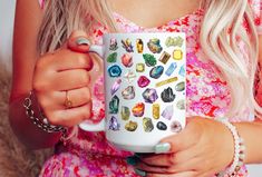 a woman is holding a coffee mug with jewels on it