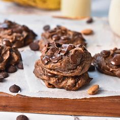 chocolate chip cookies are stacked on top of each other with milk in the back ground