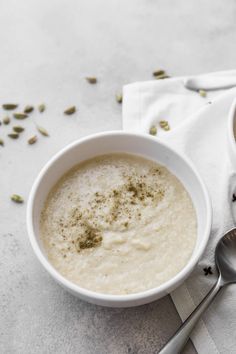 two bowls of oatmeal with spoons on the side