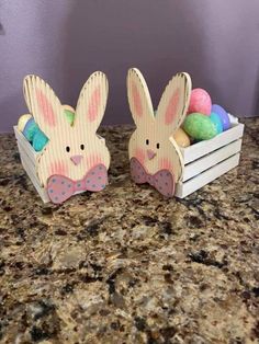 two wooden easter bunnies sitting on top of a counter