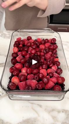 a glass dish filled with strawberries on top of a counter