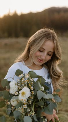 a woman holding a bouquet of flowers in her hands