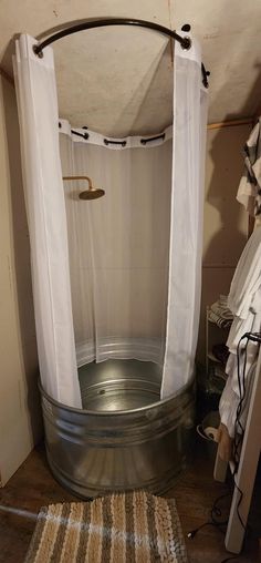 an old tub with curtains hanging from it's sides in a room that is being used as a shower