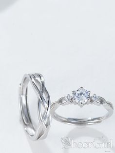 two wedding rings with one diamond on top and the other in white gold, sitting next to each other