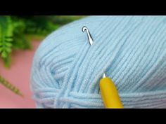 a ball of blue yarn with a needle in it