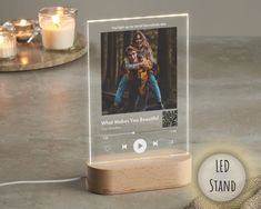 a wooden stand with an mp3 player on it next to candles and a glass jar