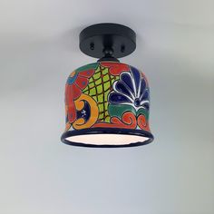 a multicolored ceiling light hanging from the ceiling in a room with white walls