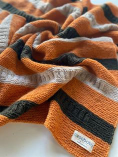 an orange and black striped scarf on a white surface