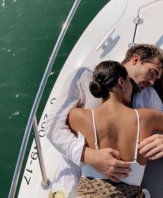 a man and woman embracing on a boat