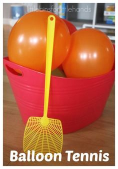 an orange and yellow ball in a red bucket with a rake on it that says balloon tennis