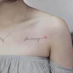 a woman with a tattoo saying be strong on her chest