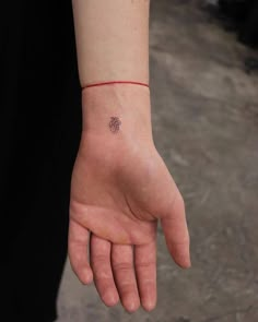 a person's hand with a small tattoo on it