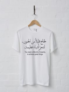 "\"You need a little bit of insanity, to achieve great things.\" in Arabic Shirt. This design has a foreign language saying in traditional Arabic handwriting style including English translation of it, that gives motivation for continuity and success.  Add it to your wardrobe or give it as the perfect gift! High-Quality Gildan 64000 Soft-Style T-Shirt comes with lovely soft feel to touch and wear. These tees are super comfortable, have an awesome fit and quality. Details: - 4.5 oz/yd²  Fabric. - Inspirational Graphic Print T-shirt As Gift, Statement Shirts Graphic Tees, Arabic Handwriting, Art Arabic, Cool Shirt Designs, Word Shirts, Handwriting Styles, Textile Prints Design, Cute Shirt Designs