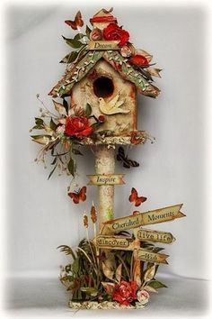 a birdhouse decorated with flowers and butterflies