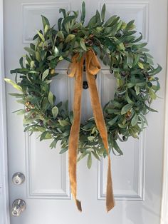 a green wreath hanging on the front door