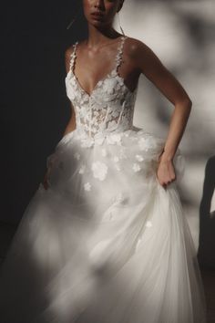 a woman in a white wedding dress with flowers on it