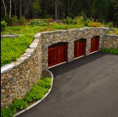 a stone wall with two garage doors on each side