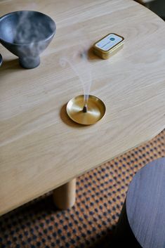 a wooden table with a phone on top of it next to a cup and saucer