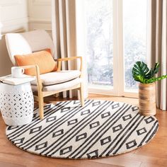 a living room with a chair, rug and potted plant