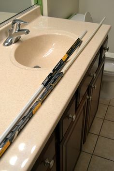 a bathroom with a sink, mirror and two large toothbrushes on the counter