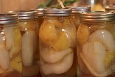 several jars filled with pickles sitting on top of a table