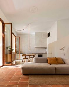 a living room filled with furniture next to a kitchen