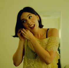 a woman in a yellow dress brushing her teeth