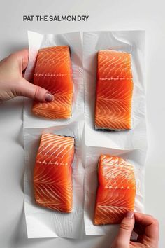 four pieces of salmon sitting on top of white parchment paper with the words pat the salmon dry