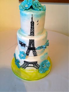 a three tiered cake decorated with the eiffel tower