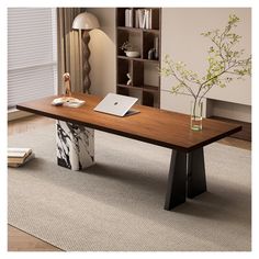 a wooden table sitting on top of a rug next to a book case and lamp