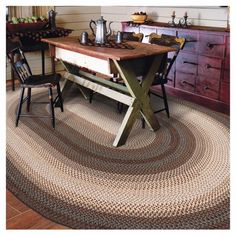 a table with two chairs and a rug on the floor