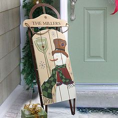 a wooden sign that says the millers on it next to a christmas tree and presents