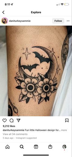 an image of a tattoo on someone's leg with flowers and bats in the moon