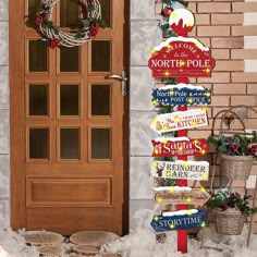 a wooden sign sitting next to a door in front of a brick building with snow on the ground