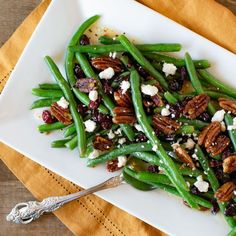 a white plate topped with green beans and pecans