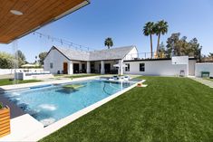 a backyard with a swimming pool surrounded by grass