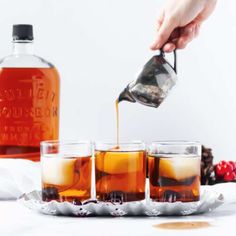 a person pours tea into four glasses