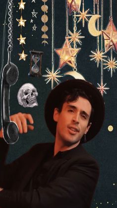 a man wearing a black hat and holding a phone to his ear with stars hanging from the ceiling