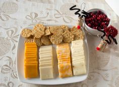 cheese, crackers and cranberries are arranged on a plate