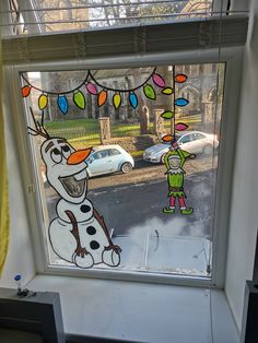 a window with a frosty snowman drawn on it