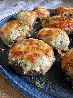 several stuffed mushrooms are on a blue plate