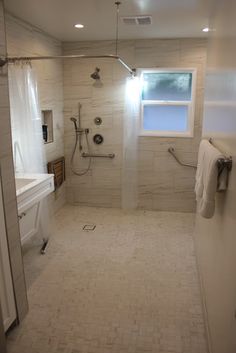 a bathroom with a sink, toilet and shower in it's stall area next to a window