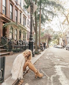 a woman sitting on the side of a street