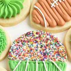 decorated cookies with frosting and sprinkles are arranged on a white surface