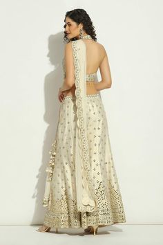 Ivory halter neck padded blouse with mirror, zari thread, crystal drops embroidery. Paired with panelled sharara and scallop bordered dupatta. - Aza Fashions Halter Neck Blouse, Halter Neck Blouses, Embroidery Mirror, Padded Blouse, Dupion Silk, Sharara Set, Silk Embroidery, Crystal Drop, Embroidered Blouse