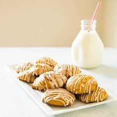 a white plate topped with cookies next to a bottle of milk