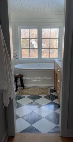 an open door leading to a bathroom with black and white checkered tile flooring