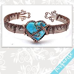 a blue heart shaped bracelet with filigrees and wire work on the clasp