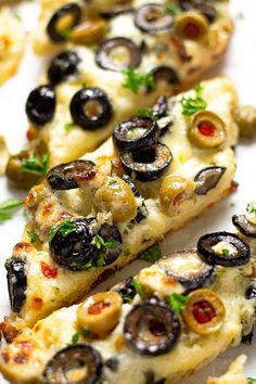 sliced pizza with olives and herbs on it